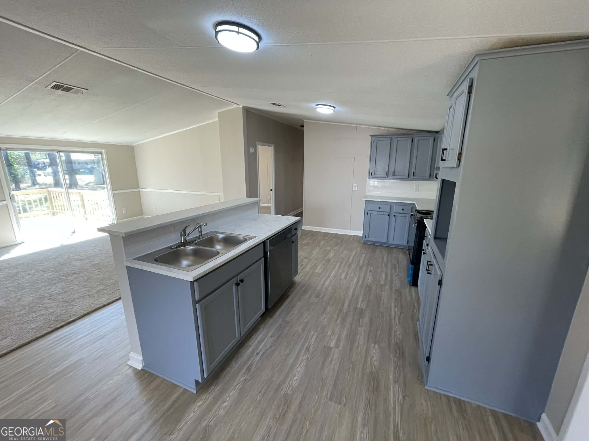105 Senimor Court Perry, GA 31069 - Photo 10 of 27 a kitchen with a sink stove and wooden floor