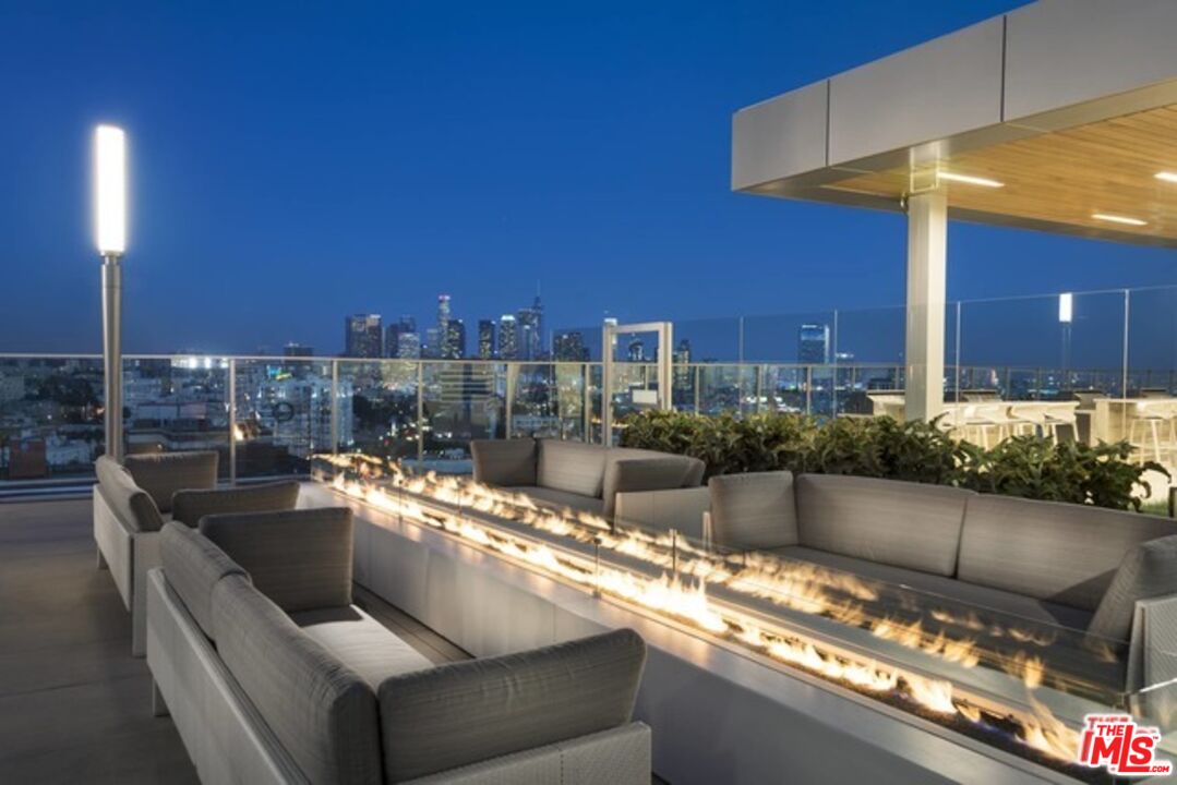 3033 Wilshire Boulevard, Unit 802 Los Angeles, CA 90020 - Photo 29 of 31 a living room with stainless steel appliances kitchen island granite countertop a sink and a black umbrella