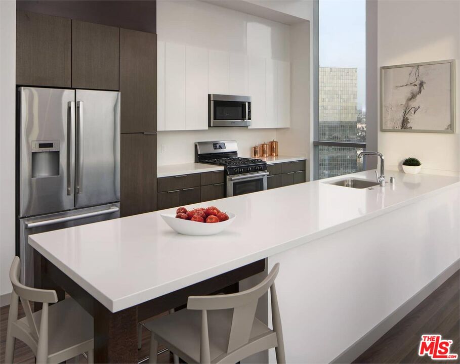 3033 Wilshire Boulevard, Unit 802 Los Angeles, CA 90020 - Photo 6 of 31 a kitchen with a table a refrigerator and a sink