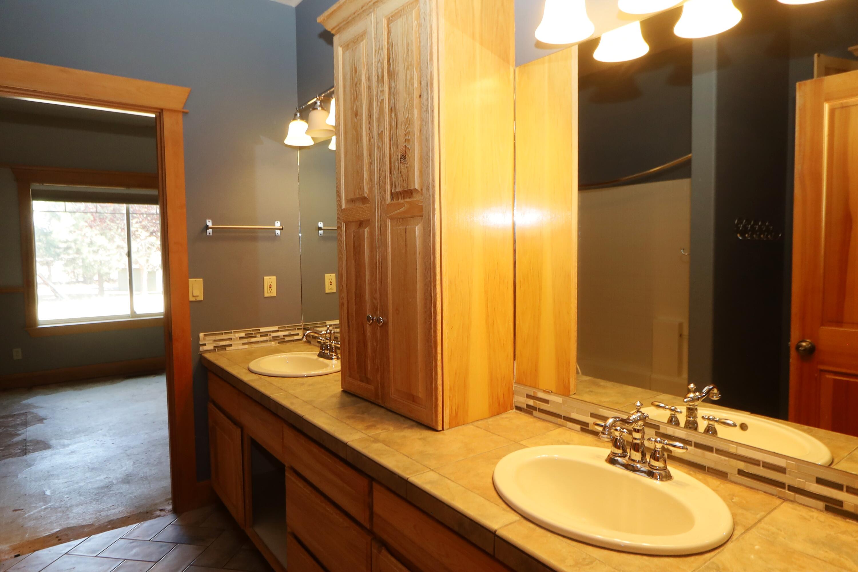 21491 Bear Creek Road Bend, OR 97701 - Photo 24 of 45 a bathroom with a double vanity sink and a mirror