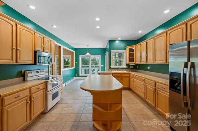 a kitchen with stainless steel appliances granite countertop a sink a stove and a refrigerator