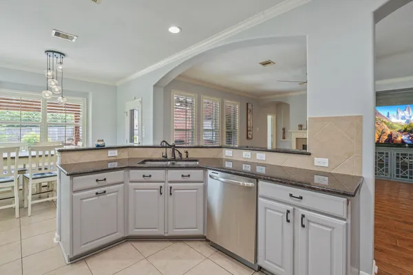 a kitchen with white cabinets and sink