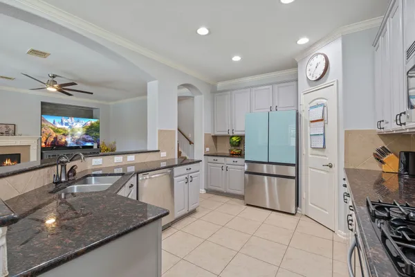 a kitchen with stainless steel appliances granite countertop a sink and a refrigerator