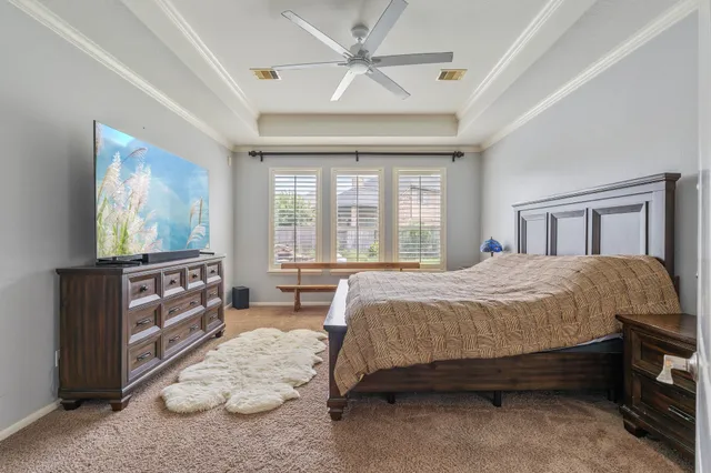 a spacious bedroom with a bed and a dresser