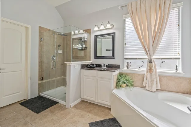 a bathroom with a tub sink and mirror