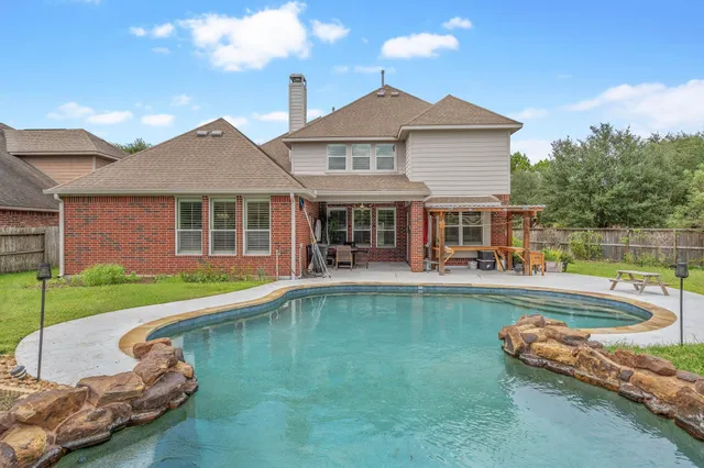 a view of a house with swimming pool and a yard