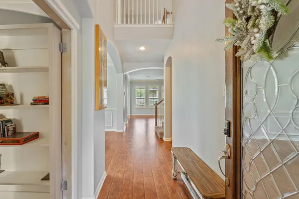 a view of hallway with wooden floor and cabinets