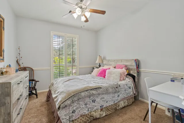 a bedroom with a bed and a table chair