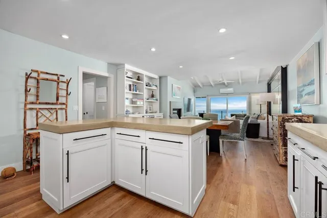 a kitchen with stainless steel appliances granite countertop a sink a stove and microwave with wooden floor