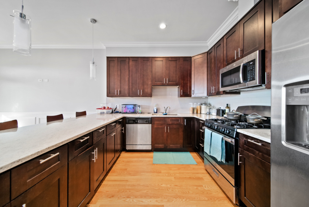 3336 West Irving Park Road, Unit 2 Chicago, IL 60618 - Photo 2 of 9 a kitchen with stainless steel appliances granite countertop a stove top oven a sink dishwasher and a refrigerator with wooden cabinets