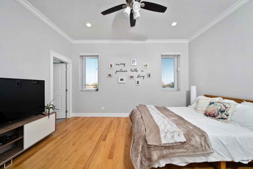 3336 West Irving Park Road, Unit 2 Chicago, IL 60618 - Photo 6 of 9 a bedroom with a bed and a flat screen tv