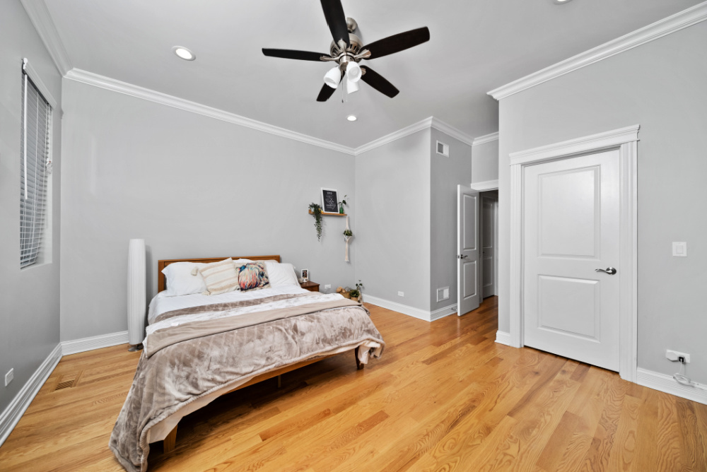 3336 West Irving Park Road, Unit 2 Chicago, IL 60618 - Photo 8 of 9 a bedroom with a bed ceiling fan and a wooden floor