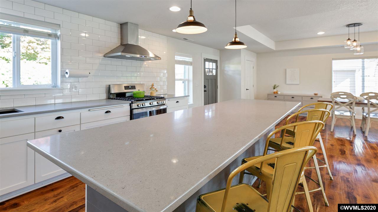 790 Southeast Fir Villa Road Dallas, OR 97338 - Photo 13 of 38 a kitchen with stainless steel appliances a table chairs refrigerator and cabinets