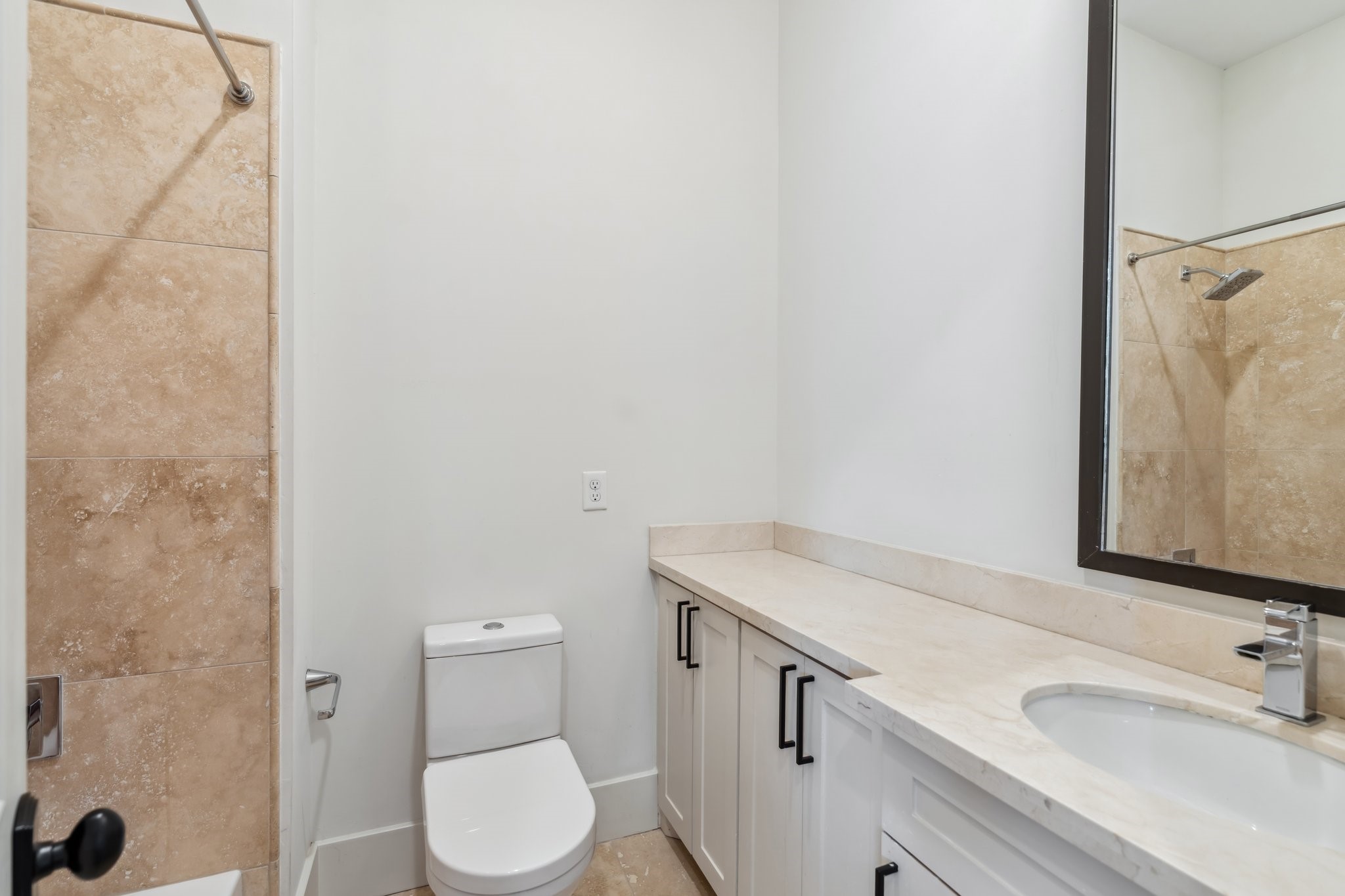 815 East 27th Street Houston, TX 77009 - Photo 27 of 44 The ensuite bathroom is both functional and stylish, featuring a large vanity with ample storage, a decorative mirror, and vanity lights that add a soft glow. The tub/shower combination offers convenience.