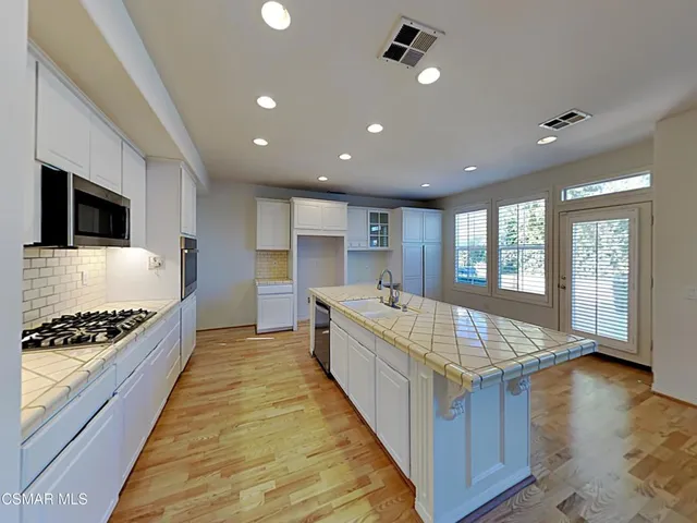 a large kitchen with kitchen island granite countertop a large counter top and stainless steel appliances
