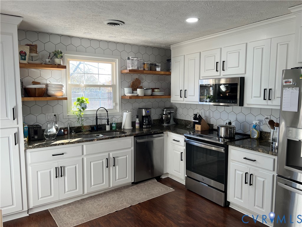 4192 Range Road Mechanicsville, VA 23111 - Photo 11 of 36 a kitchen with stainless steel appliances granite countertop a stove a sink a refrigerator a microwave and cabinets