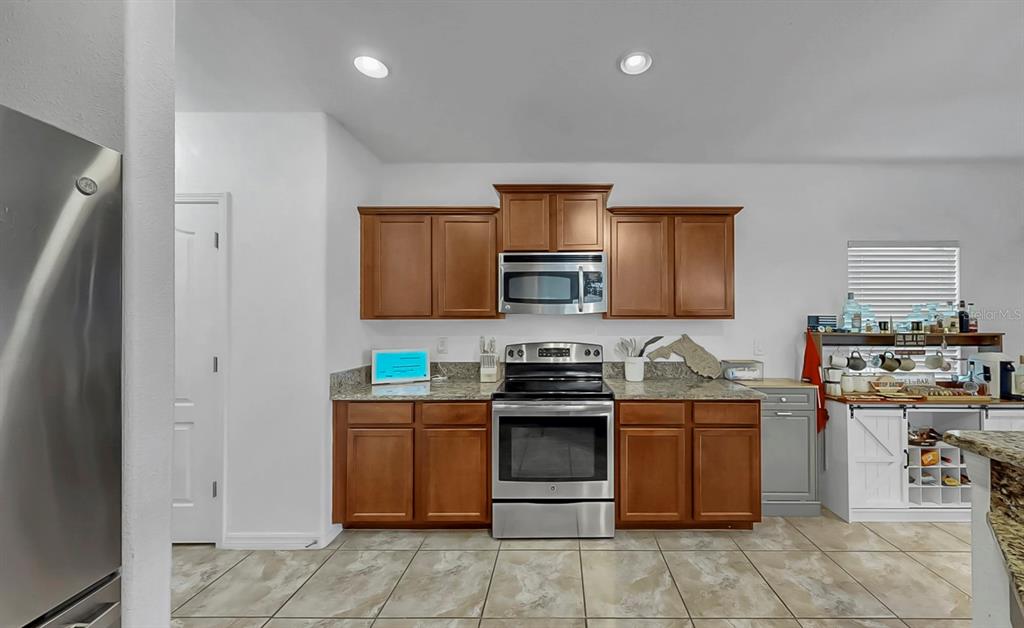 10012 Newminster Loop Ruskin, FL 33573 - Photo 15 of 59 a kitchen with stainless steel appliances granite countertop wooden cabinets a sink and dishwasher