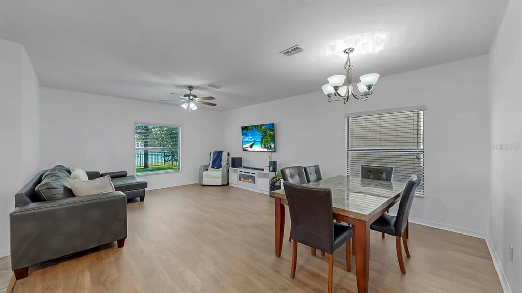 10012 Newminster Loop Ruskin, FL 33573 - Photo 19 of 59 a living room with furniture and a chandelier