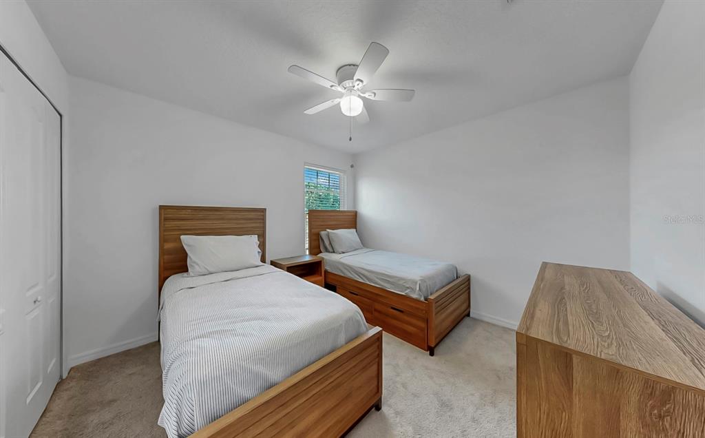 10012 Newminster Loop Ruskin, FL 33573 - Photo 35 of 59 a bedroom with two beds and a chandelier