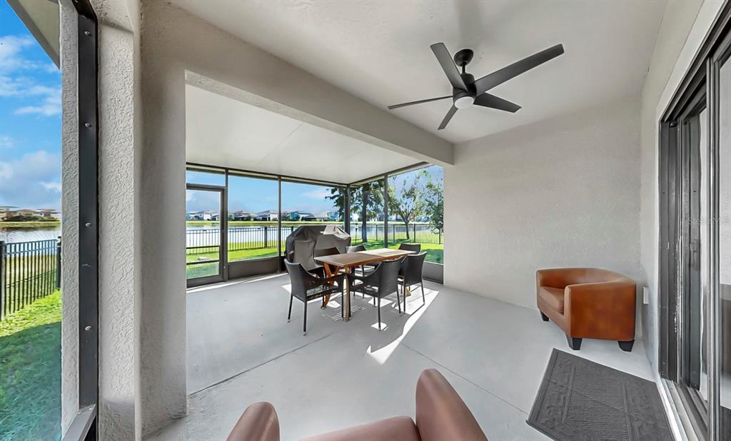 10012 Newminster Loop Ruskin, FL 33573 - Photo 39 of 59 a dining room with furniture a floor to ceiling window and a table