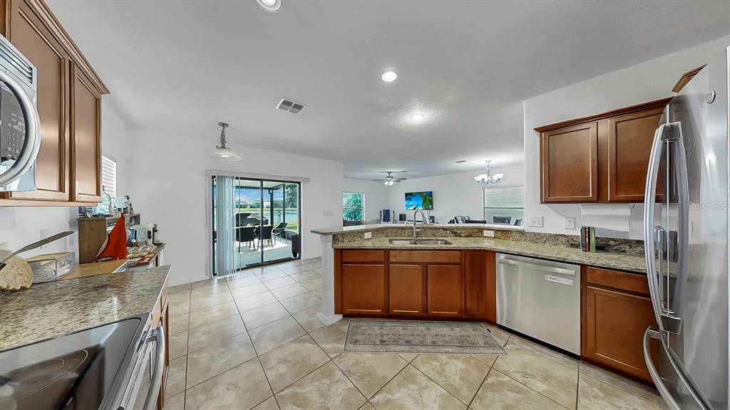 10012 Newminster Loop Ruskin, FL 33573 - Photo 9 of 59 a kitchen with stainless steel appliances granite countertop a sink stove and cabinets