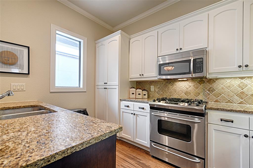 6269 Oram Street, Unit 10 Dallas, TX 75214 - Photo 9 of 25 a kitchen with granite countertop cabinets stainless steel appliances and wooden floor
