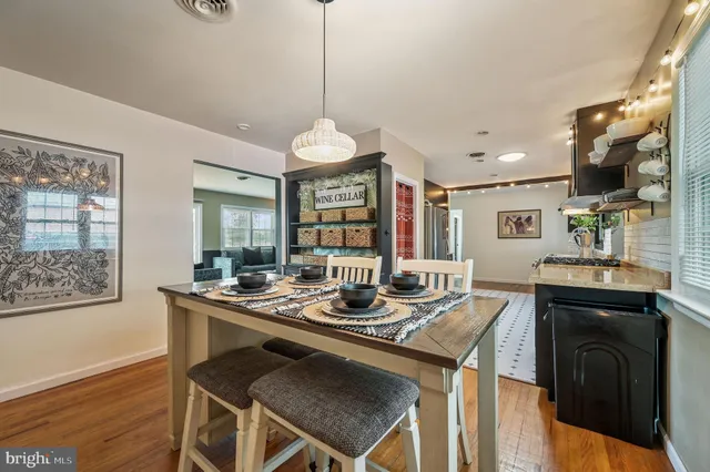 a kitchen with a table chairs and wooden floor