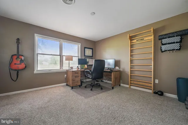 a view of a workspace with furniture and a window