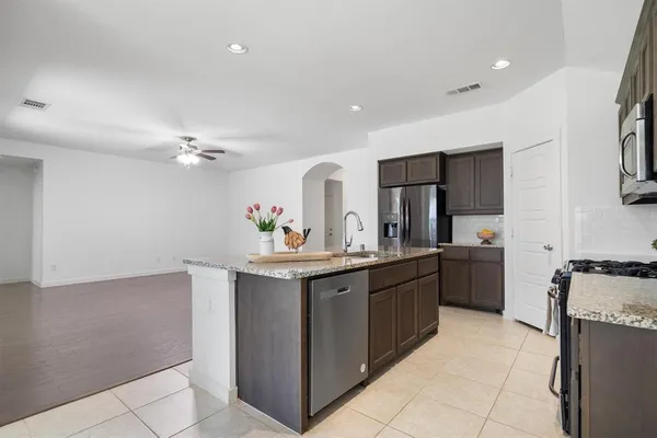 a kitchen with stainless steel appliances a sink counter space and cabinets