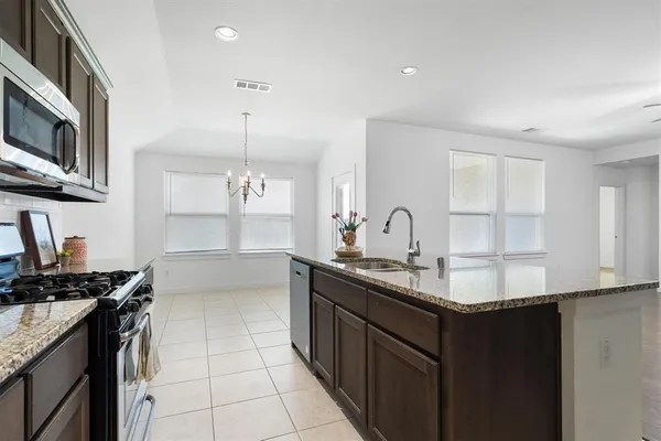 a kitchen with stainless steel appliances granite countertop a sink stove and cabinets