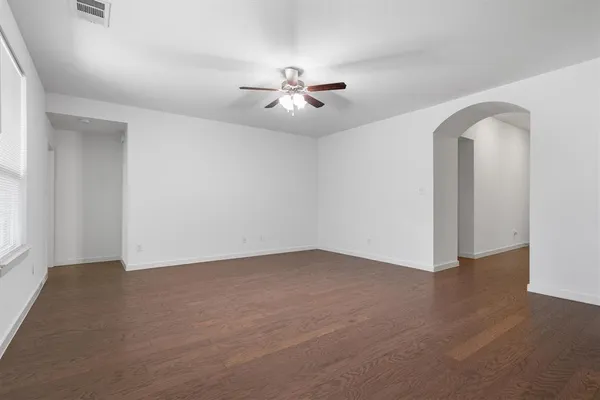 an empty room with windows and fan
