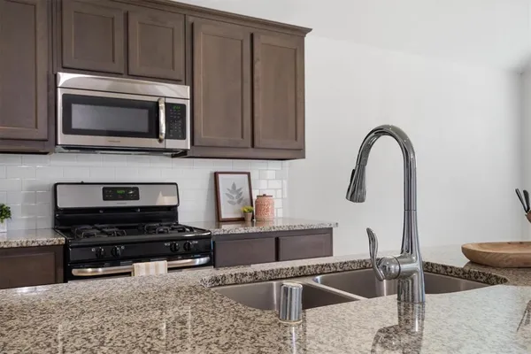 a kitchen with a stove a microwave and a sink