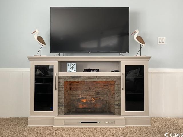 469 Sandpebble Surfside Beach, SC 29575 - Photo 11 of 39 Detailed view of carpet floors, a decorative wall, a wainscoted wall, and a lit fireplace