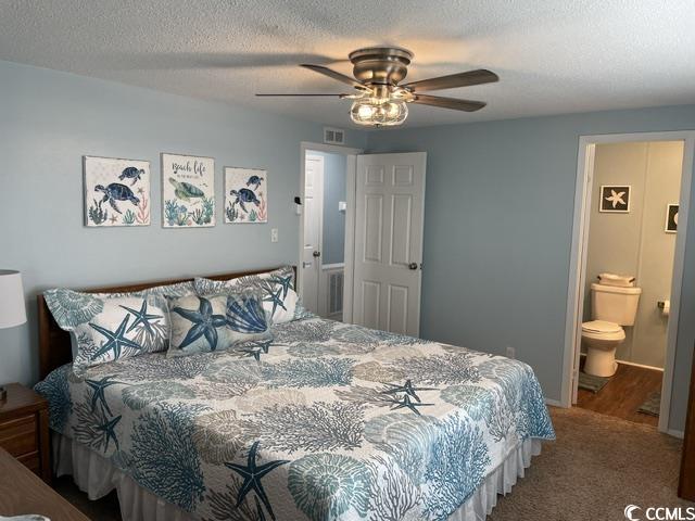 469 Sandpebble Surfside Beach, SC 29575 - Photo 21 of 39 Carpeted bedroom with a textured ceiling, ceiling fan, and ensuite bath
