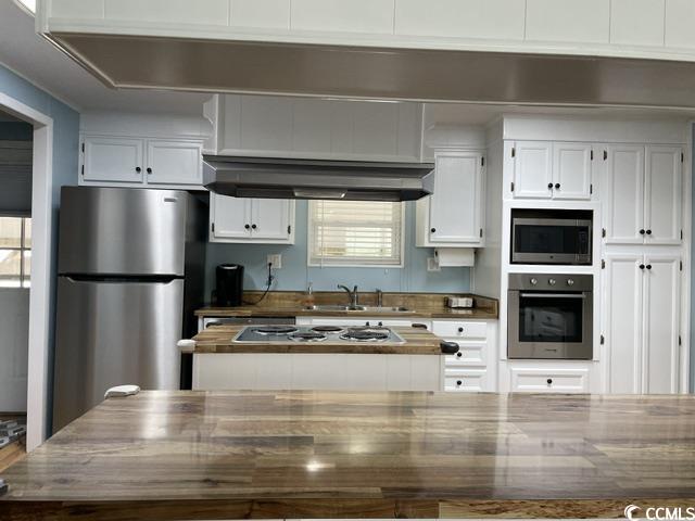 469 Sandpebble Surfside Beach, SC 29575 - Photo 3 of 39 Kitchen featuring stainless steel appliances, under cabinet range hood, white cabinets, and wooden counters