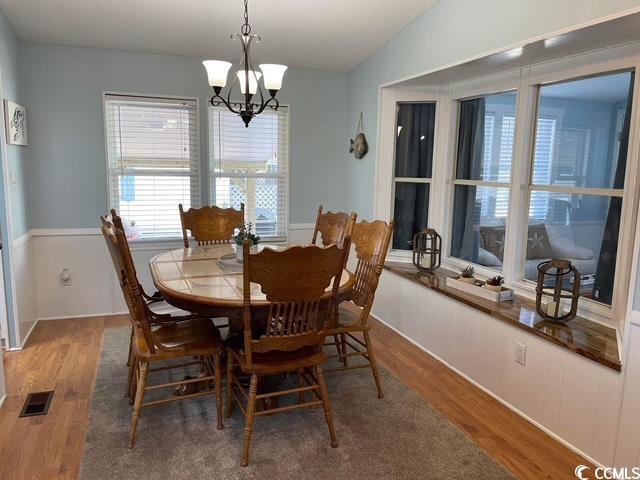469 Sandpebble Surfside Beach, SC 29575 - Photo 7 of 39 Dining area with wood finished floors and a chandelier