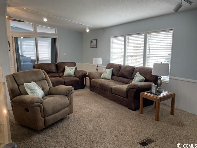 469 Sandpebble Surfside Beach, SC 29575 - Photo 8 of 39 Carpeted living room with rail lighting, plenty of natural light, and a ceiling fan