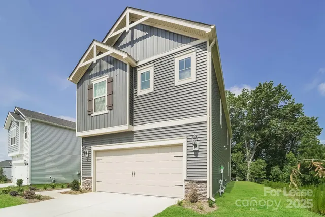 a view of a house with a yard and garage