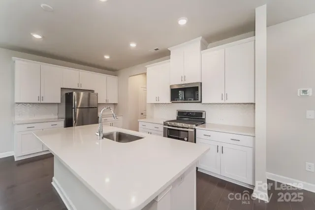 a kitchen with stainless steel appliances a stove refrigerator sink and microwave