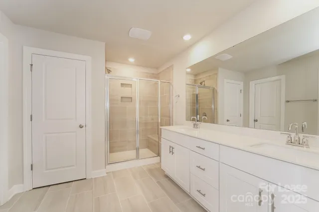 a large bathroom with a shower sink and mirror