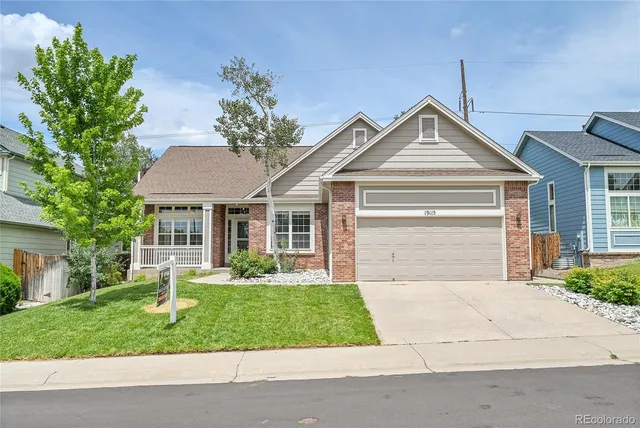 a front view of a house with a yard and plants