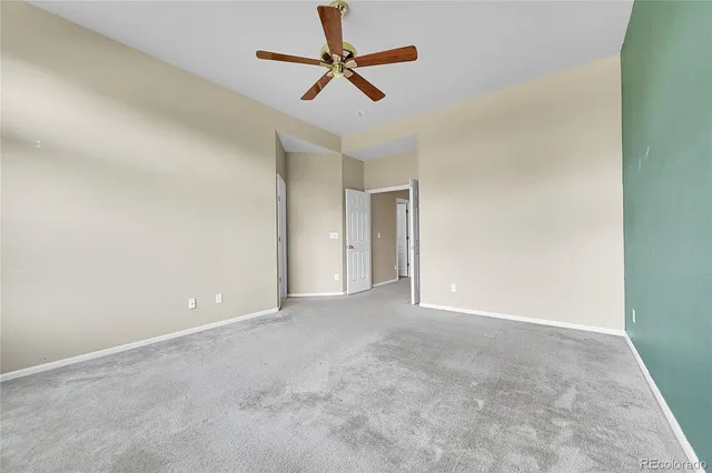 an empty room with chandelier fan
