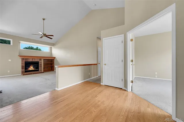 an empty room with windows and a fireplace