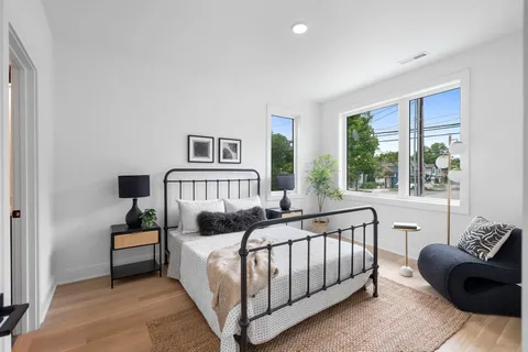 a bedroom with furniture and a large window