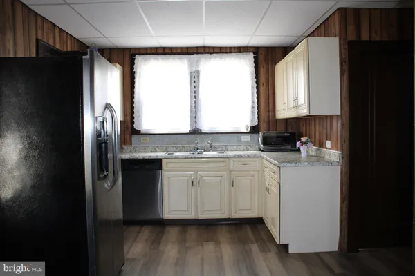 a kitchen with granite countertop a refrigerator and a sink
