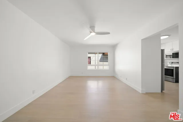 wooden floor in an empty room with a kitchen