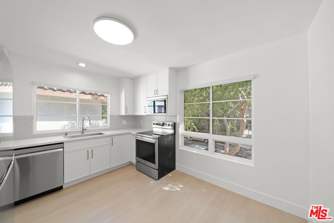 1201 Ohio Avenue, Unit 4 Long Beach, CA 90804 - Photo 6 of 18 a large kitchen with granite countertop a sink and stove top oven