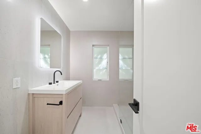 a bathroom with a sink a mirror and shower