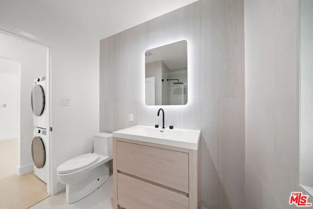 a bathroom with a toilet sink vanity and mirror