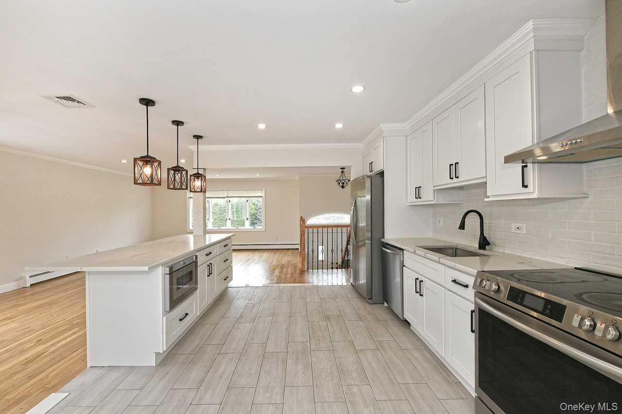 107 Beverly Road Massapequa, NY 11758 - Photo 7 of 41 a kitchen with a stove a sink and a refrigerator